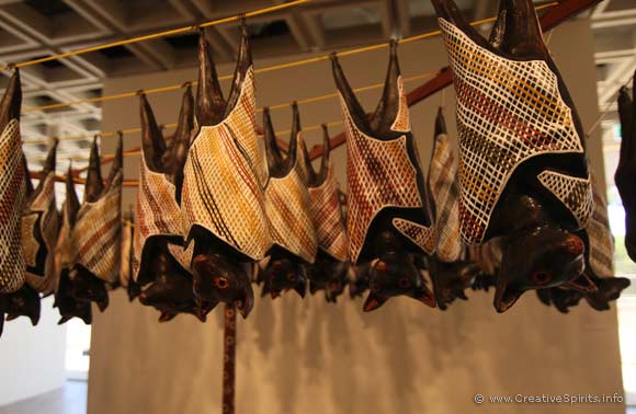Detail showing the carved wooden fruit bats hanging from a clothes line.