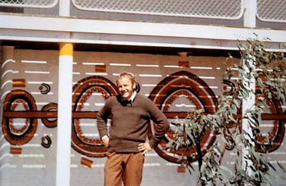 Geoffrey Bardon stands in front of a wall of the school at Papunya.