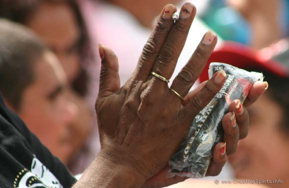 Aboriginal woman holding a cigarette and pack of tobacco in her hands.