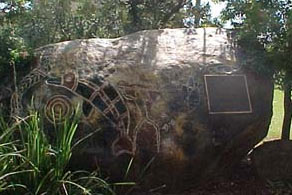 Sacred rock with totem paintings and an inscription.