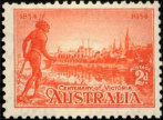 An Aboriginal man looks over a river and the city behind it.