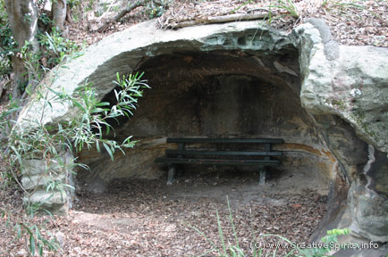 Aboriginal rock shelter with a bench in it.