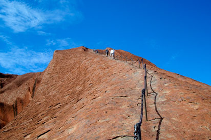 Tourists climbing Uluru