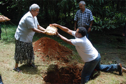 Aboriginal remains wrapped in Paperbark are put in a hole in the ground.