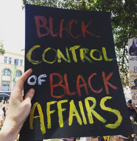 A poster reading 'Black control of black affairs'.