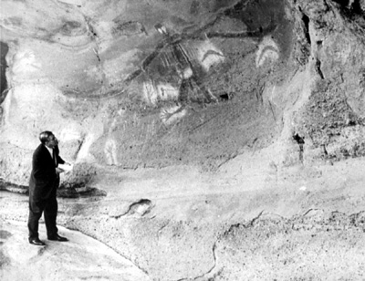 Percy Haslam stands at Biami Cave, Millbrodale, NSW, where he analyses an Aboriginal rock painting of Biame.