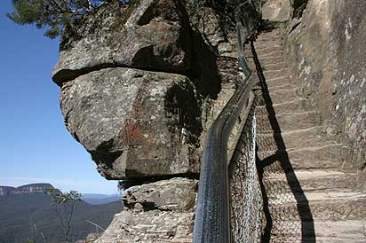 Furber Steps. To the right of the rail the steps, to the left a view across Jamison Valley to Mount Solitary.