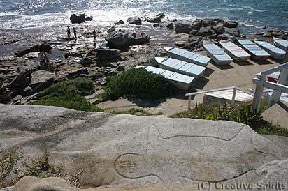 Bondi Ben Buckler. It's striking how close ancient Aboriginal engravings and modern living can be. The staircase is visible on the right hand side of the image, the graffiti on the far left side at the rock's edge.