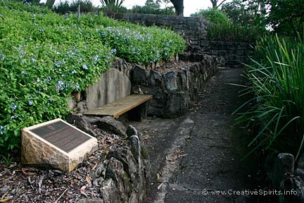 Terraced garden with a memorial plaque in the foreground.