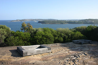 Grotto Point Site. The engravings are protected by massive railway sleepers. Looking south-east you can see Middle Head and in the distance left South Head.